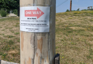Photo of sign on Big A Trail post that reads "One Way" on a red arrow.