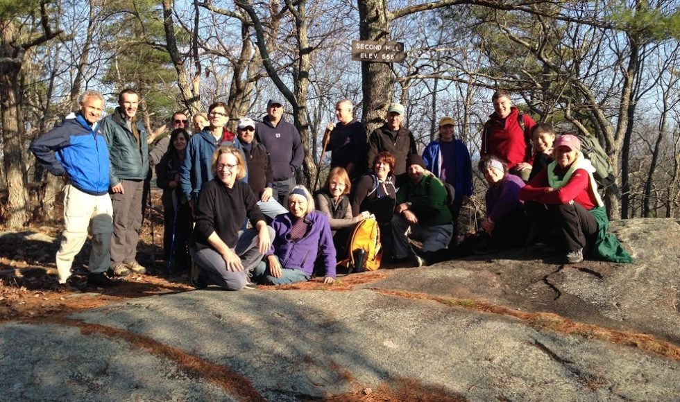 group of hikers in front of Second Hill elevation sign at Mount Agamenticus